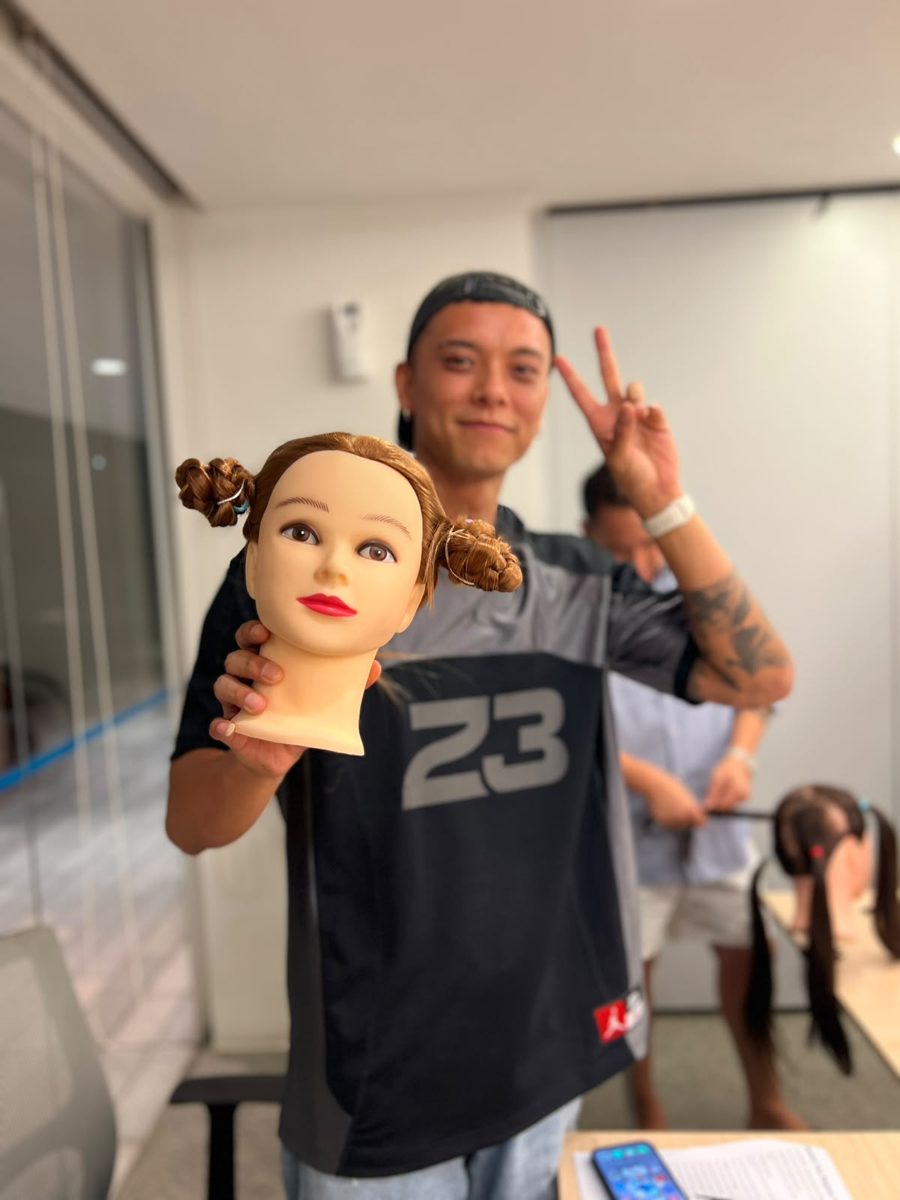 A dad proudly holding up the double-bun braids he just did